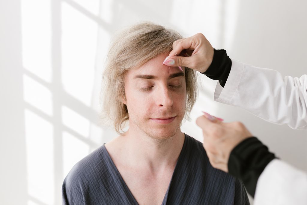 A man in a spa setting receiving acupuncture treatment for relaxation and holistic wellness.